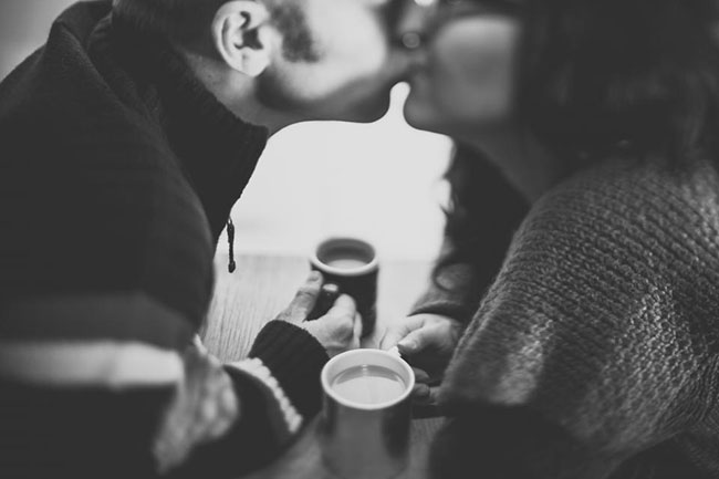 Couple Kissing with Coffee Cup on Hand